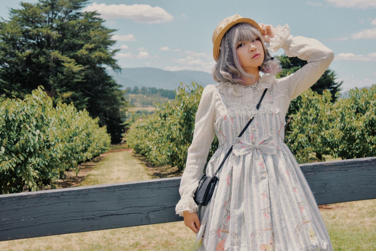 services-04 Stylish young woman in vintage Lolita dress poses in picturesque orchard.