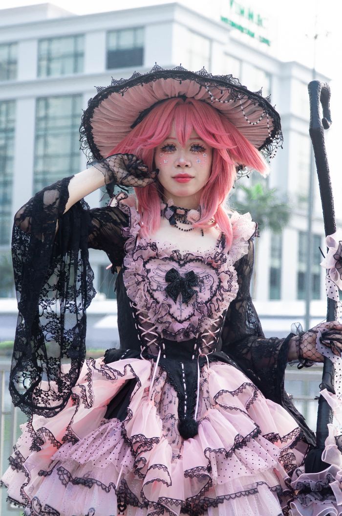 heros-img A person dressed in a Gothic Lolita attire poses outdoors, featuring intricate lace and frills.