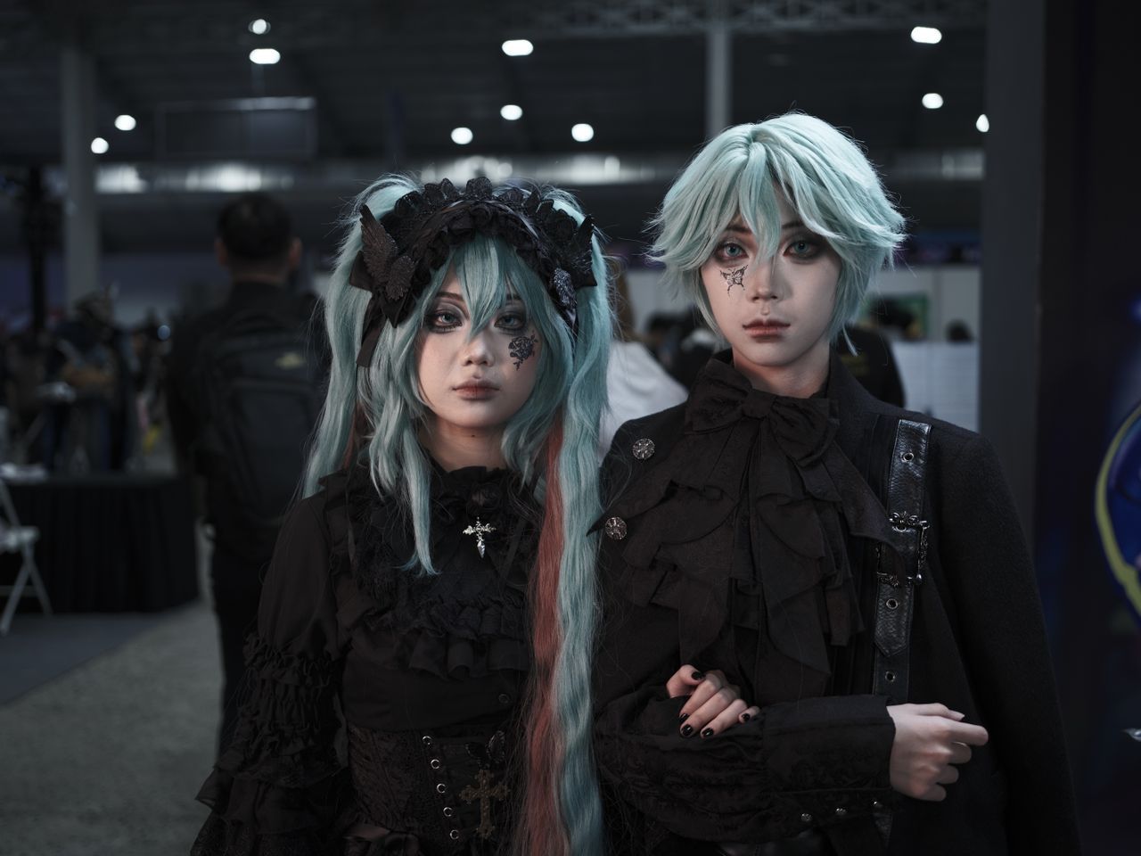 The Art of Drawing Readers In: Your attractive post title goes here Two individuals in gothic cosplay at an indoor anime convention. Unique and vibrant costumes.